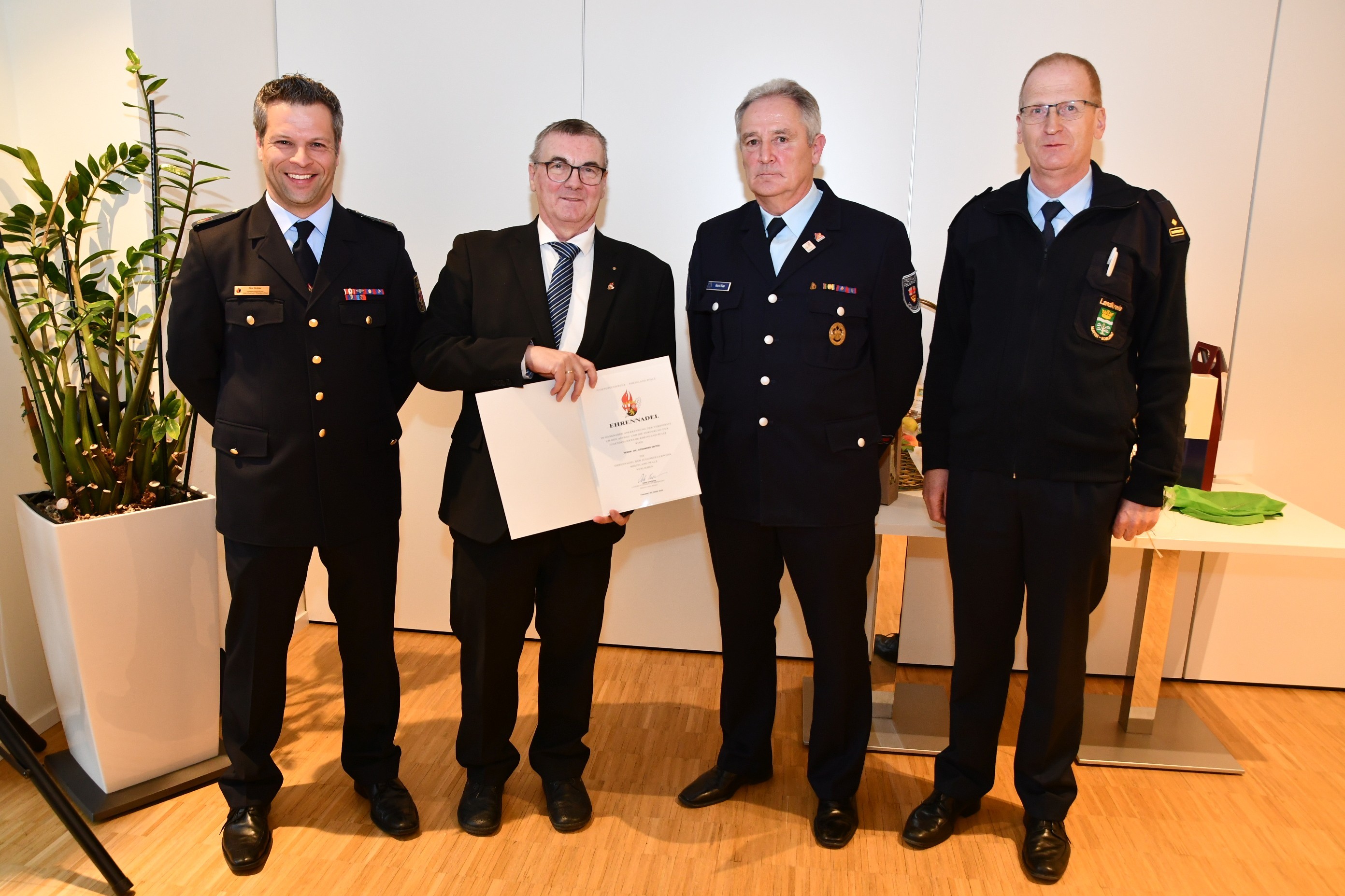 Landrat Dr. Alexander Saftig (2.v.l.) wurde die Ehrennadel der Jugendfeuerwehr Rheinland-Pfalz samt Urkunde von Landesjugendfeuerwehrwart Dirk Ströder (links), Kreisjugendfeuerwehrwart Horst Klee (2.v.r.) sowie Brand- und Katastrophenschutzinspekteur Rainer Nell überreicht.