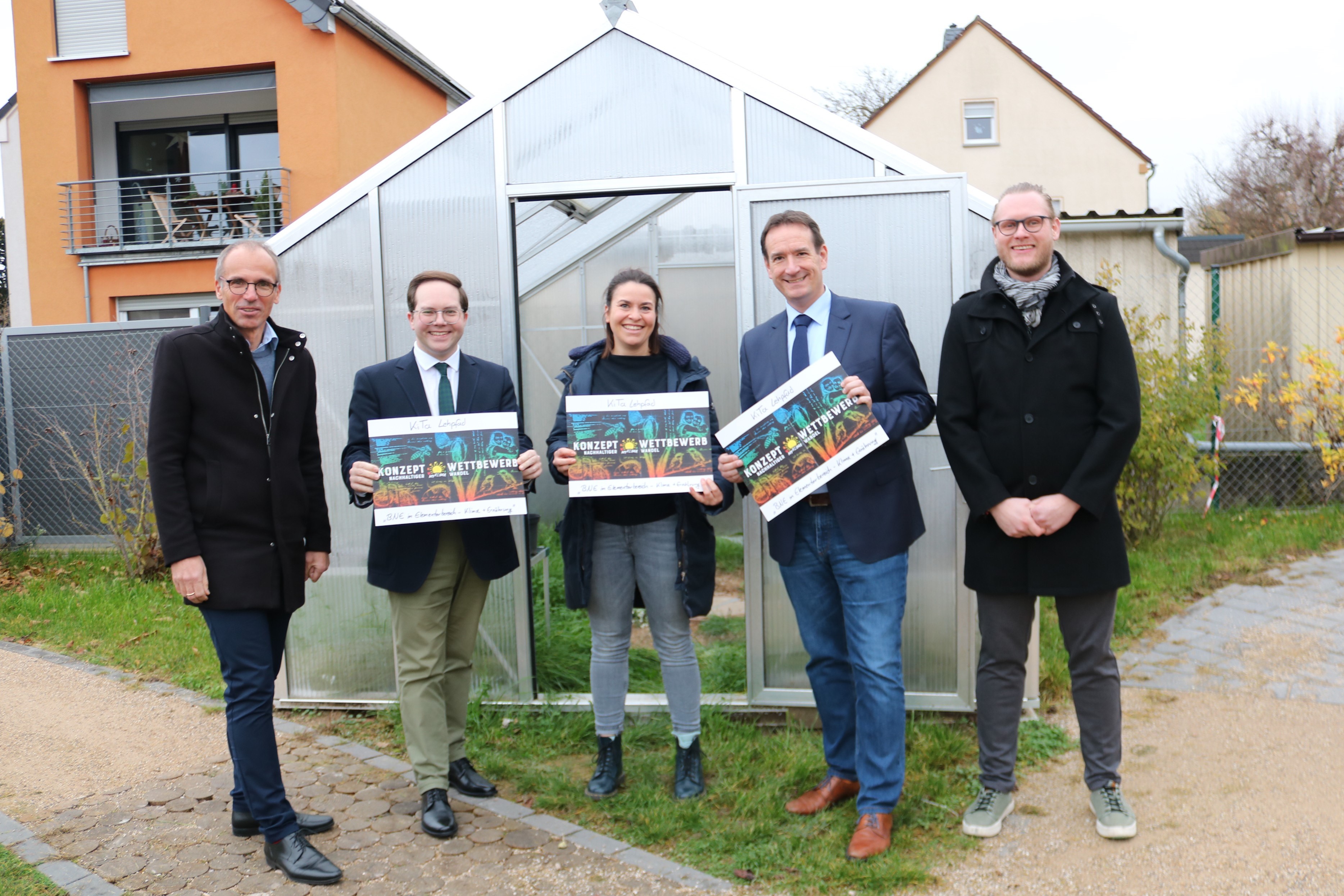 Die kommissarische Leiterin der Kita Lehpfad, Ann-Kathrin Müller, freut sich stellvertretend für die gesamte Kita, als einer der drei Sieger im Wettbewerb „Nachhaltiger Wandel MYK“, über ein Lehr-Gewächshaus. Mit ihr freuen sich (von links): Sven Normann, Leiter der Volkshochschule Weißenthurm, Pascal Badziong, Erster Kreisbeigeordneter des Landkreises Mayen-Koblenz, Thomas Przybylla, Bürgermeister der Verbandsgemeinde Weißenthurm, und Nico Hickel, Klimaschutzmanager der Kreisverwaltung Mayen-Koblenz.