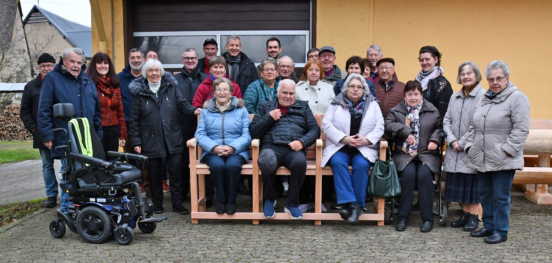 Landrat Dr. Alexander Saftig (7.v.l.), Projektleiterin „Bewegung in die Dörfer“ Lea Bales (3.v.l.) und Westenergie-Kommunalmanager, Patrick Ley (hintere Reihe 4.v.l.) haben jüngst die Seniorenbank an die Ortsgemeinde Dreckenach übergeben. 