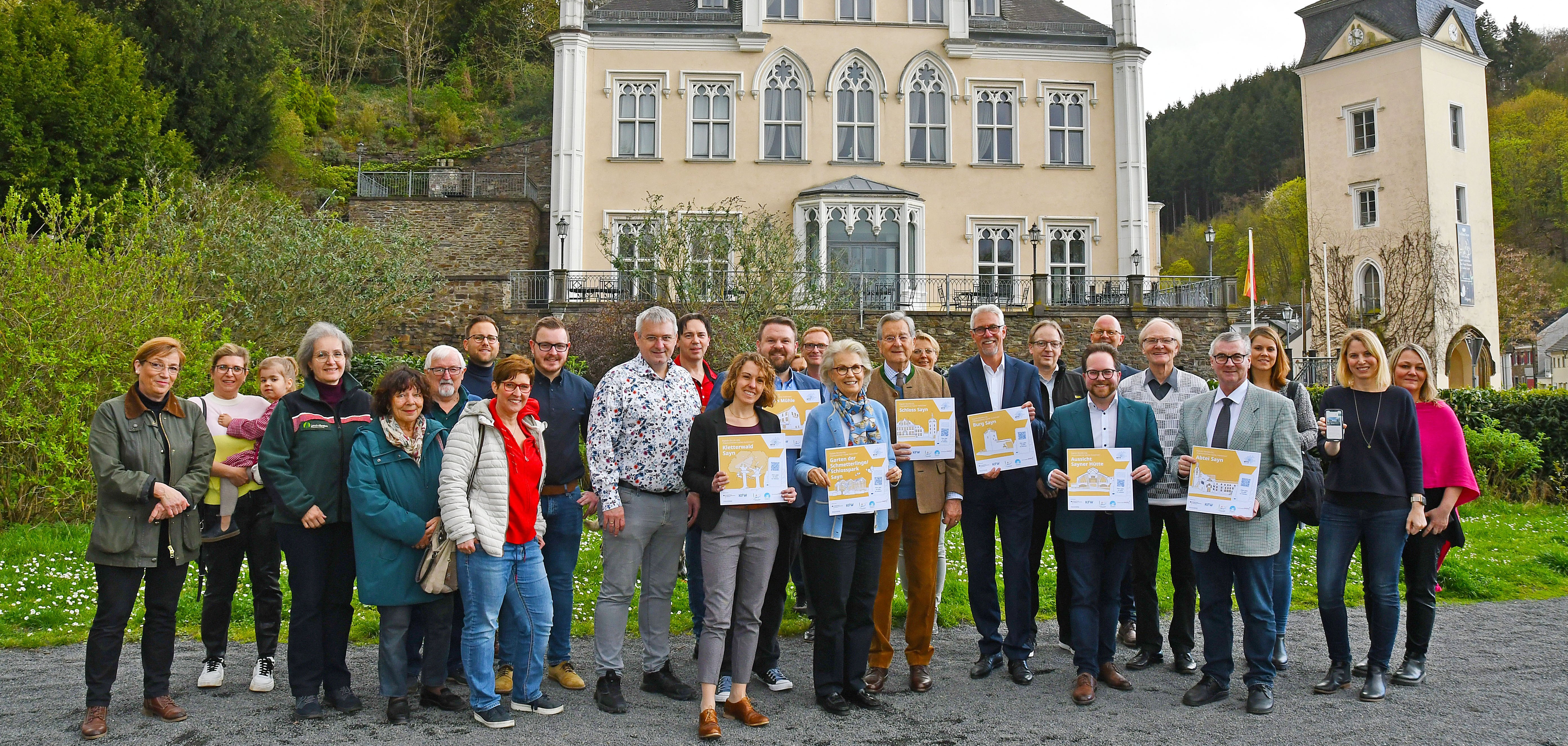 Im Beisein des Fürstenpaars Alexander und Gabriela zu Sayn-Wittgenstein-Sayn (Mitte) und vieler weiterer Gäste eröffnete Landrat Dr. Alexander Saftig (4.v.r.) im Schlosspark Sayn die erste „Digitale Wanderung“ im Landkreis Mayen-Koblenz. 