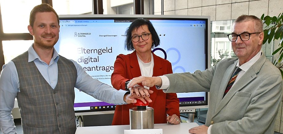 Drücken den symbolischen Startknopf für die digitale Antragstellung beim Elterngeld in MYK: Landrat Dr. Alexander Saftig (rechts), Heike Schäfer, Leiterin des Referats Erziehungsleistungen, und Tobias Querbach, zuständiger Projektmanager für die Digitalisierung des Landkreises Mayen-Koblenz.