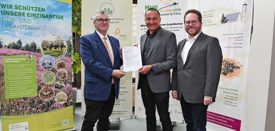 Der Stiftungsvorstandsvorsitzende Pascal Badziong (rechts) und Landrat Dr. Alexander Saftig (links) nahmen den Bewilligungsbescheid aus den Händen von Dr. Peter Sound vom Umweltministerium entgegen. 