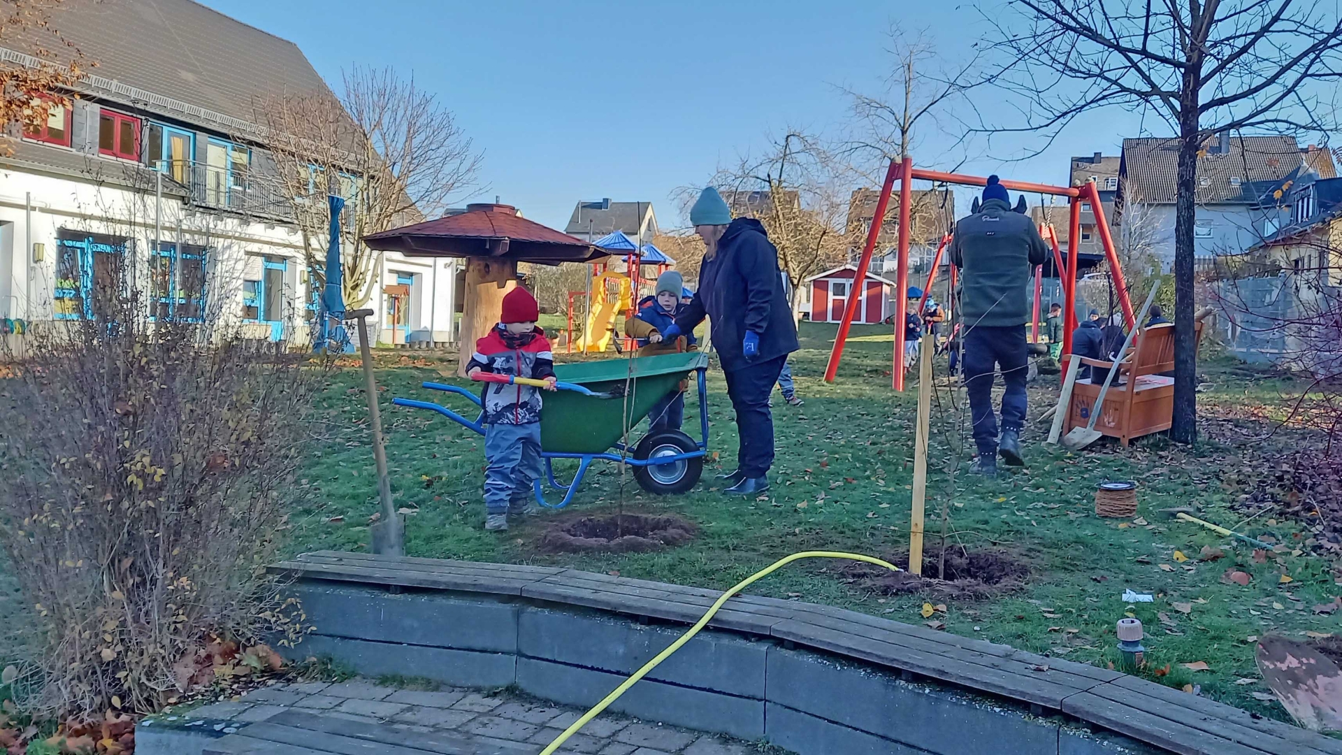 Eltern, Erzieher, Hausmeister und Kita-Kinder beteiligten sich gemeinsam an der Pflanzaktion in der Kita St. Martin in Ochtendung. Auf den Freiflächen entstanden Spiel- und Schattengebüsche, ergänzt durch eine Sonnen- und Sichtschutzhecke sowie einen gespendeten Apfelbaum.  
