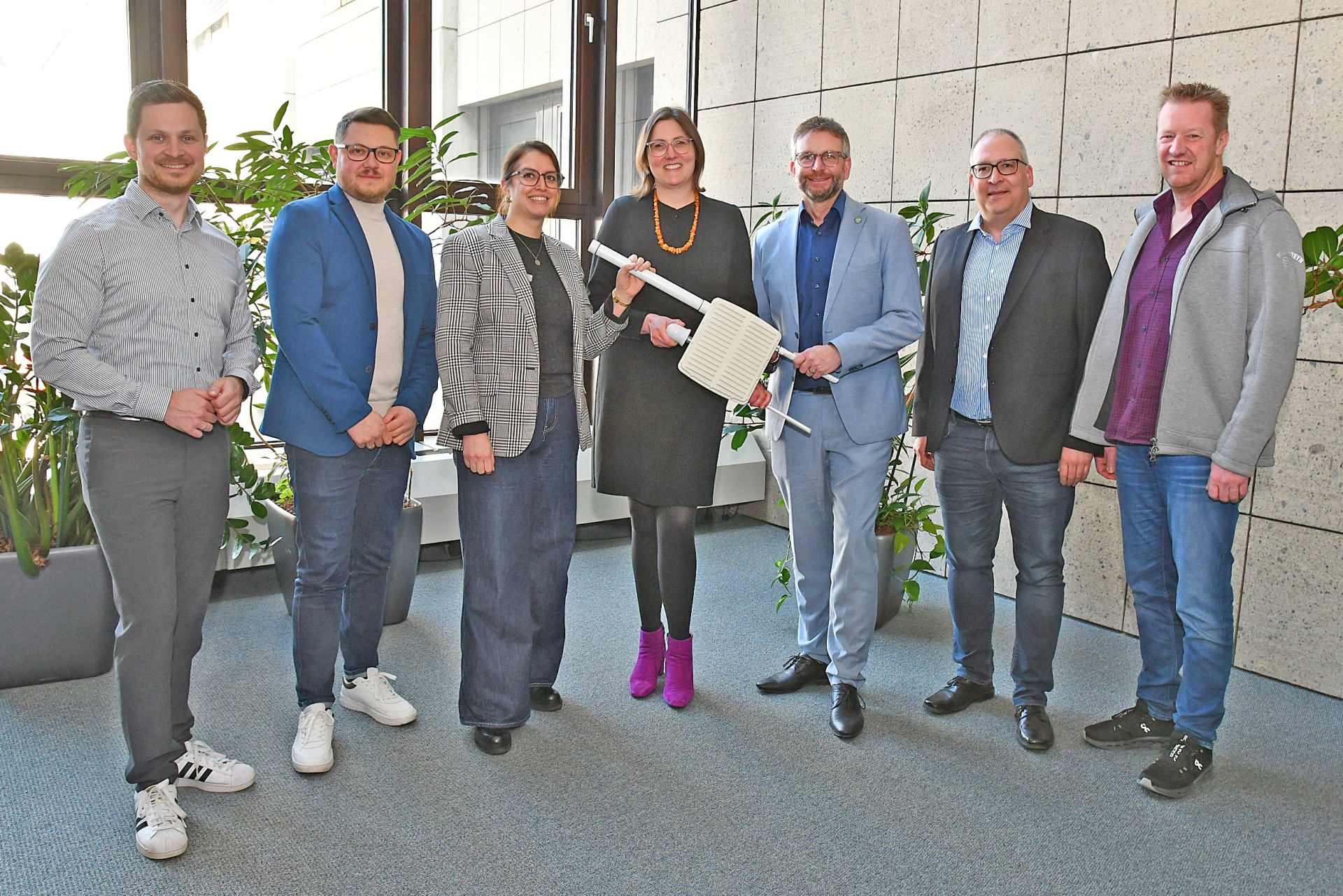 Landrat Marko Boos (3. von rechts), Kathrin Laymann, Bürgermeisterin der Verbandsgemeinde Rhein-Mosel (Mitte), sowie Vertreter des WVZ Maifeld-Eifel und der Smarten Region MYK10 präsentieren eine LoRaWAN-Antenne. 