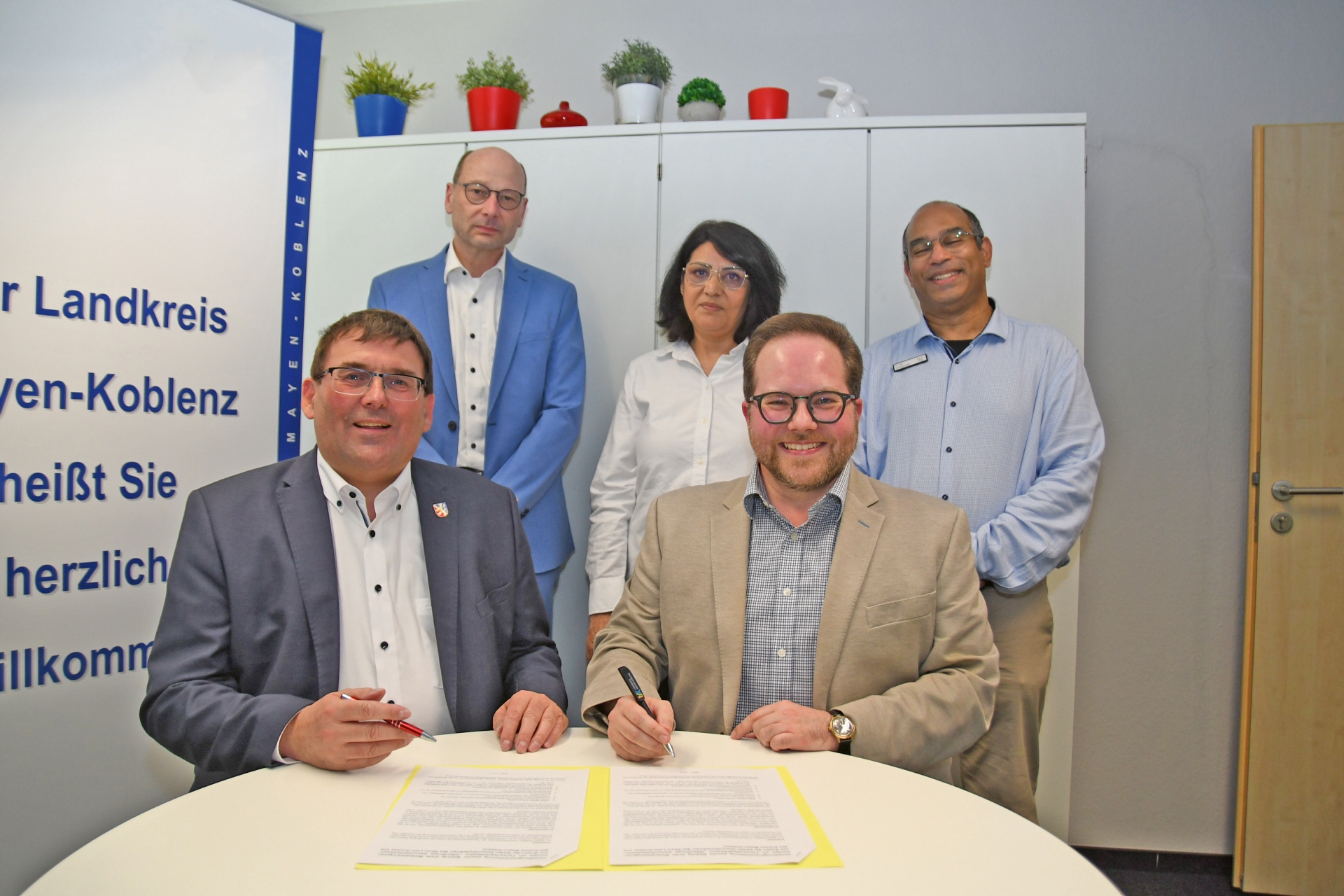Der Erste Kreisbeigeordnete Pascal Badziong (vorne von rechts) und Jörg Denninghoff, Landrat des Rhein-Lahn-Kreises haben jüngst eine Verwaltungsvereinbarung zur Facharztausbildung im Gesundheitsamt Mayen-Koblenz unterzeichnet. Ebenfalls anwesend waren (hinten von rechts) Dr. med. Raj Chakupurakal, Leiter des Gesundheitsamtes Mayen-Koblenz, seine Kollegin Amtsärztin Zeba Parwani sowie Thorsten Butzke, Büroleiter im Rhein-Lahn-Kreis. 