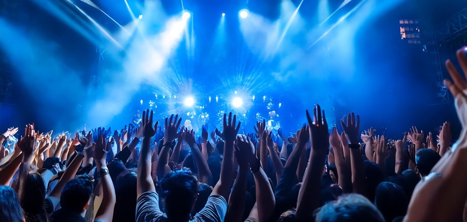 Fotografía en concierto lleno de personas con luces de color azul